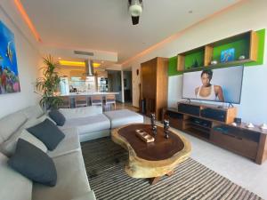 a living room with a couch and a tv at Peninsula Nuevo Vallarta in Mezcales