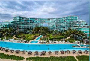 a resort with a pool and a beach with umbrellas at Peninsula Nuevo Vallarta in Mezcales