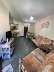 a living room with a couch and a table at Praia das Toninhas - Condomínio Summer Time APTO 33 in Ubatuba