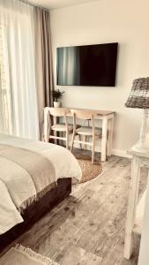 a bedroom with a bed and a table and a tv at Morze To Tu in Mielno