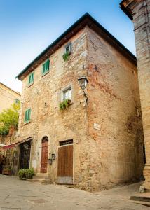 stary kamienny budynek z drzwiami i oknami w obiekcie Casa Raffaella 1 Tuscan charm in medieval Suvereto w mieście Suvereto