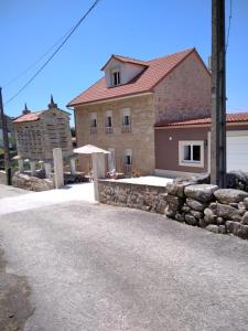 una casa con un muro di pietra e un edificio di Casa de Tanajildo a Lira