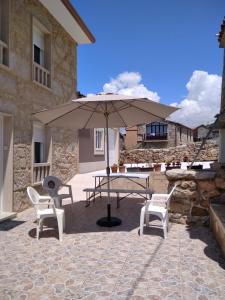 un tavolo, sedie e un ombrellone in un patio di Casa de Tanajildo a Lira