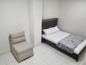 ein kleines Schlafzimmer mit einem Bett und einem Stuhl in der Unterkunft Cómodo apartament tipo loft en El Peñol in El Peñol