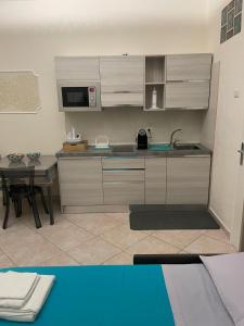 a kitchen with a sink and a microwave and a table at Le Tre Querce in Bisceglie