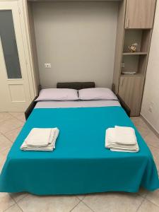 a bedroom with a blue bed with towels on it at Le Tre Querce in Bisceglie