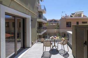 a patio with a table and chairs on a balcony at AM Suites Kefalonia in Argostoli