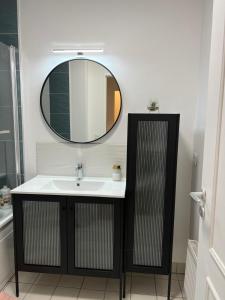un baño con lavabo y espejo en Excellent Apartment for Familly, en Clichy 6 fotos más
