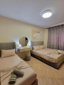 a room with two beds and a table with a mirror at Bella Vista Durazzo in Golem +6 photos