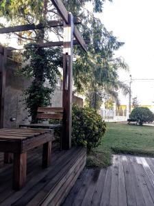 a wooden bench sitting on a wooden deck at Hotel Parque in Villa Mercedes