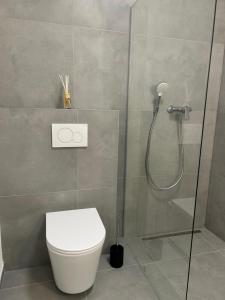 a bathroom with a toilet and a glass shower at AR SANTORINI white in Košice +12 photos