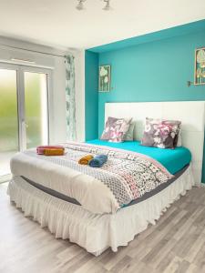 a bedroom with a large bed with blue walls at Business Room 10 minutes de Paris et Orly aéroport in Antony +5 photos