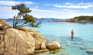 a man standing in the water in the ocean at VALENTINA HOME Costa Smeralda Vista Mar in Cugnana Verde