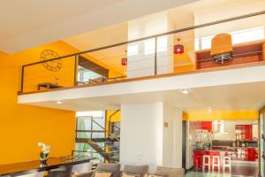 un soggiorno con scala e pareti gialle di Villa Leonor Cliffside Retreat a Calheta