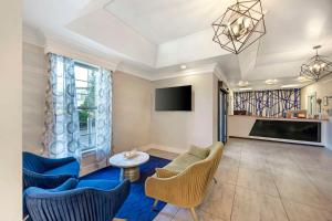 a living room with blue chairs and a tv at Best Western Brentwood in Brentwood