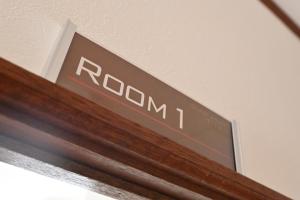 a sign on top of a wooden door at Guest House TITAN in Otaru +23 photos