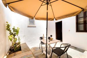 a table and chairs under a large umbrella at Mary's house Lindos in Lindos