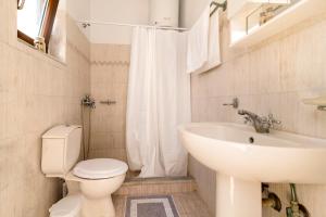 un bagno con un water bianco e un lavandino di Mary's house Lindos a Líndos Altre 16 foto