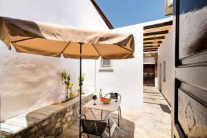 un patio con un tavolo e un ombrellone di Mary's house Lindos a Líndos