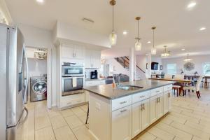 una cucina con armadi bianchi e lavandino di Ocean view 'Atlantic dream' w/pool & spa, wraparound balcony, steps to beach a Butler Beach