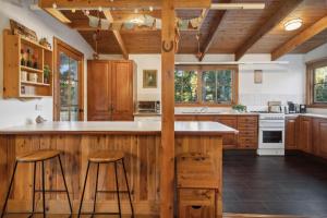 a kitchen with wooden cabinets and a counter with stools at Our Glenbogle in Medlow Bath +12 photos