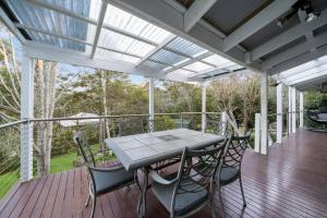 a patio with a table and chairs on a deck at Our Glenbogle in Medlow Bath