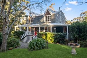 a gray house with a porch and a yard at Our Glenbogle in Medlow Bath