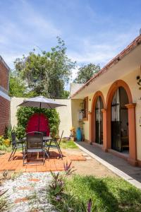 a patio with a table and an umbrella at Casa Cataleya Refugio Bohemio y Romántico en Oaxaca in Oaxaca City +28 photos