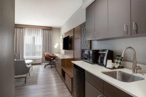 a kitchen with a sink and a microwave at Holiday Inn Blytheville by IHG in Blytheville