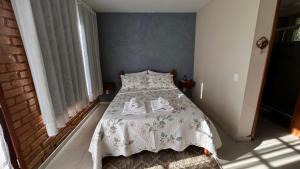 a bedroom with a bed with two towels on it at Chalé do Riacho in Nova Friburgo
