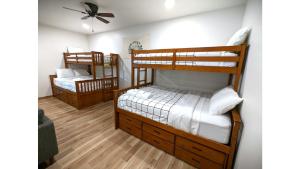 2 letti a castello in una camera con ventilatore a soffitto di The Lost Yeti Hideaway - Hot Tub - WiFi - Washer - Dryer - Fireplace - Firepit - Grill a Red River
