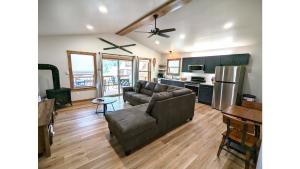 un soggiorno con divano e cucina di The Lost Yeti Hideaway - Hot Tub - WiFi - Washer - Dryer - Fireplace - Firepit - Grill a Red River