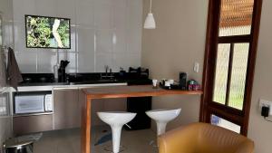 a kitchen with a counter and a table and chairs at Chalé do Riacho in Nova Friburgo
