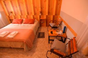 a bedroom with a bed and a table and chairs at hosteria las cachi alojamiento in Esquel