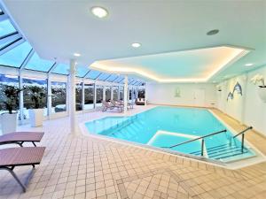 a large swimming pool in a large room with a large ceiling at Villa Sunside Schluchsee - Appartements Modern Style & Superior in Schluchsee