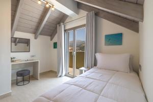 a bedroom with a bed and a desk and a window at AM Suites Kefalonia in Argostoli