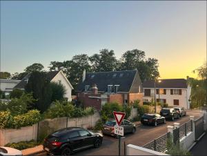 a group of cars parked on a street with houses at Belle maison avec jardin ! in Bezannes-les-Reims