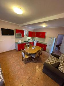a kitchen with a table and a kitchen with red cabinets at Apartments Villa-G Lustica in Tivat