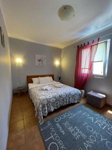 a bedroom with a bed and a red window at Apartments Villa-G Lustica in Tivat