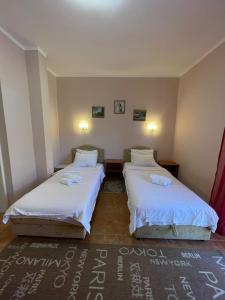 two beds in a room with white sheets at Apartments Villa-G Lustica in Tivat