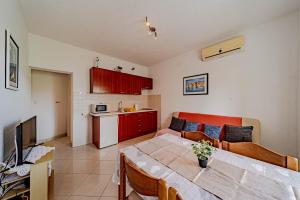 a living room with a dining table and a kitchen at Apartments by the sea Lumbarda, Korcula - 4348 in Lumbarda