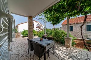a patio with a table and chairs and a building at Apartments by the sea Lumbarda, Korcula - 4348 in Lumbarda