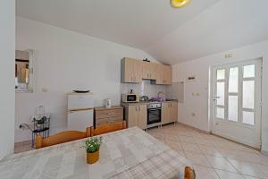 a kitchen with a table and a kitchen with a refrigerator at Apartments by the sea Lumbarda, Korcula - 4348 in Lumbarda +20 photos