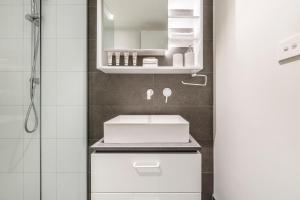 a white bathroom with a sink and a mirror at Suave Condo in Trendy PrahranSteps to Greville St in Melbourne +33 photos