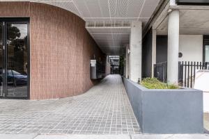 a hallway of a building with a brick wall at Suave Condo in Trendy PrahranSteps to Greville St in Melbourne