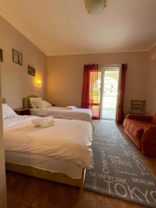 a hotel room with two beds and a couch at Apartments Villa-G Lustica in Tivat