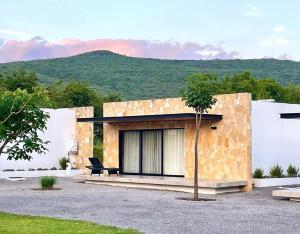 a stone house with a tree in front of it at AVE SUITES CAMPESTRES Jalpan de Serra in Cunas