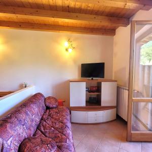 a living room with a couch and a flat screen tv at Mountain Lake Endine- Iseo Milly's Home in Bianzano +38 photos