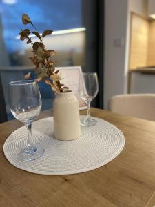 a table with two wine glasses and a vase with a plant at AR MYKONOS oasis in Košice