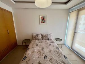 a bedroom with a bed and two stools at Zen & Welcoming CFC - Garage & Tramway in Casablanca